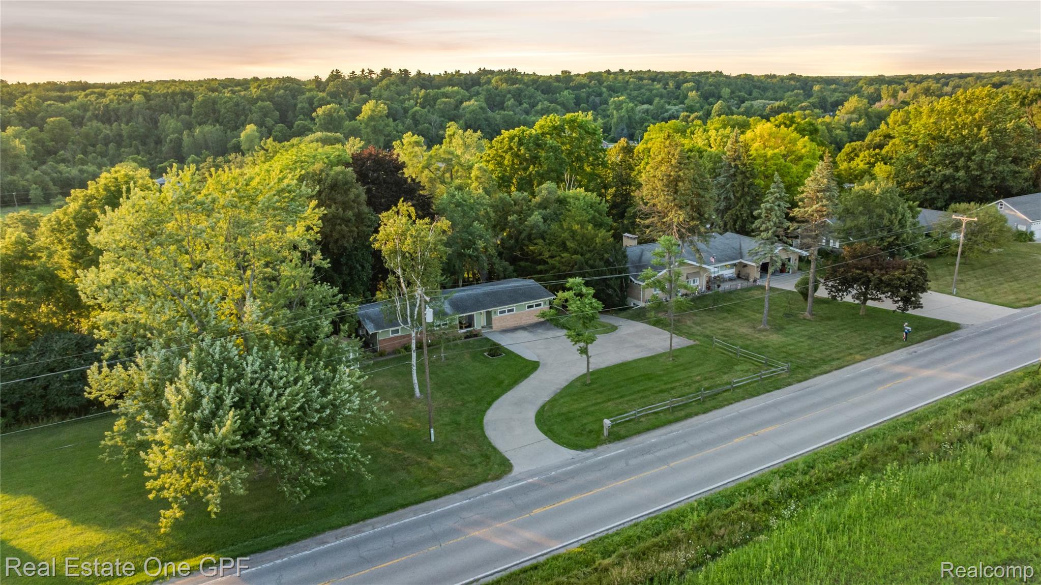 5068 Atkins Road North Street, MI 48049 - Photo 70 of 78 Expansive property featuring two distinct structures, a winding paved driveway, and mature landscaping