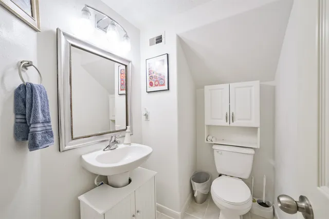 a bathroom with a toilet a sink and mirror
