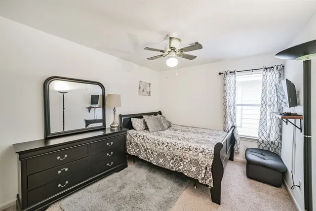 a bedroom with a bed and a mirror on the dresser