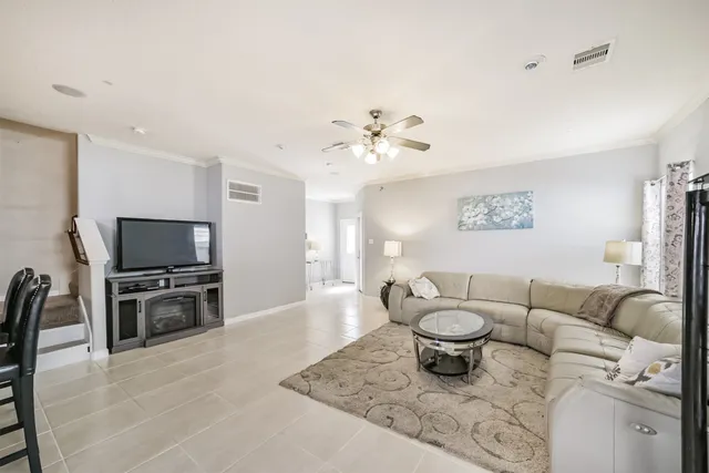 a living room with furniture a flat screen tv and a chandelier