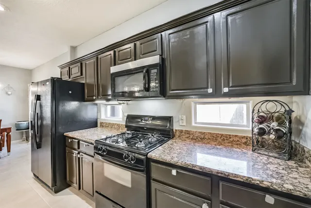 a kitchen with granite countertop stainless steel appliances and a counter space