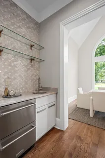 a view of a kitchen with a sink wooden cabinets and windows