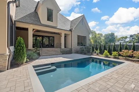 a view of a house with swimming pool and sitting area