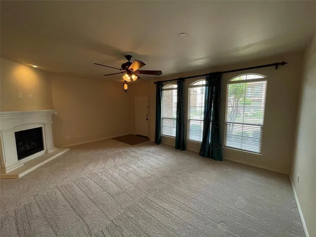 a view of an empty room with a fireplace and a window