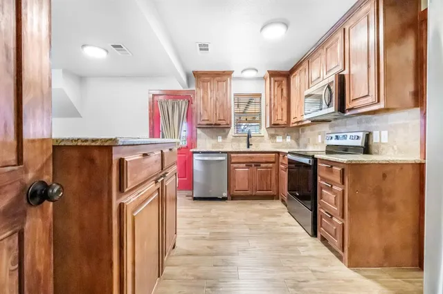 a kitchen with stainless steel appliances granite countertop a sink and a stove