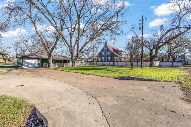 a view of the house with a big yard and palm trees