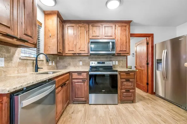 a kitchen with a refrigerator stove and sink