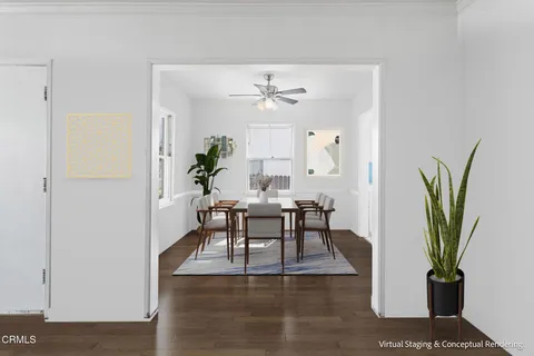 a dining room with furniture potted plants and wooden floor