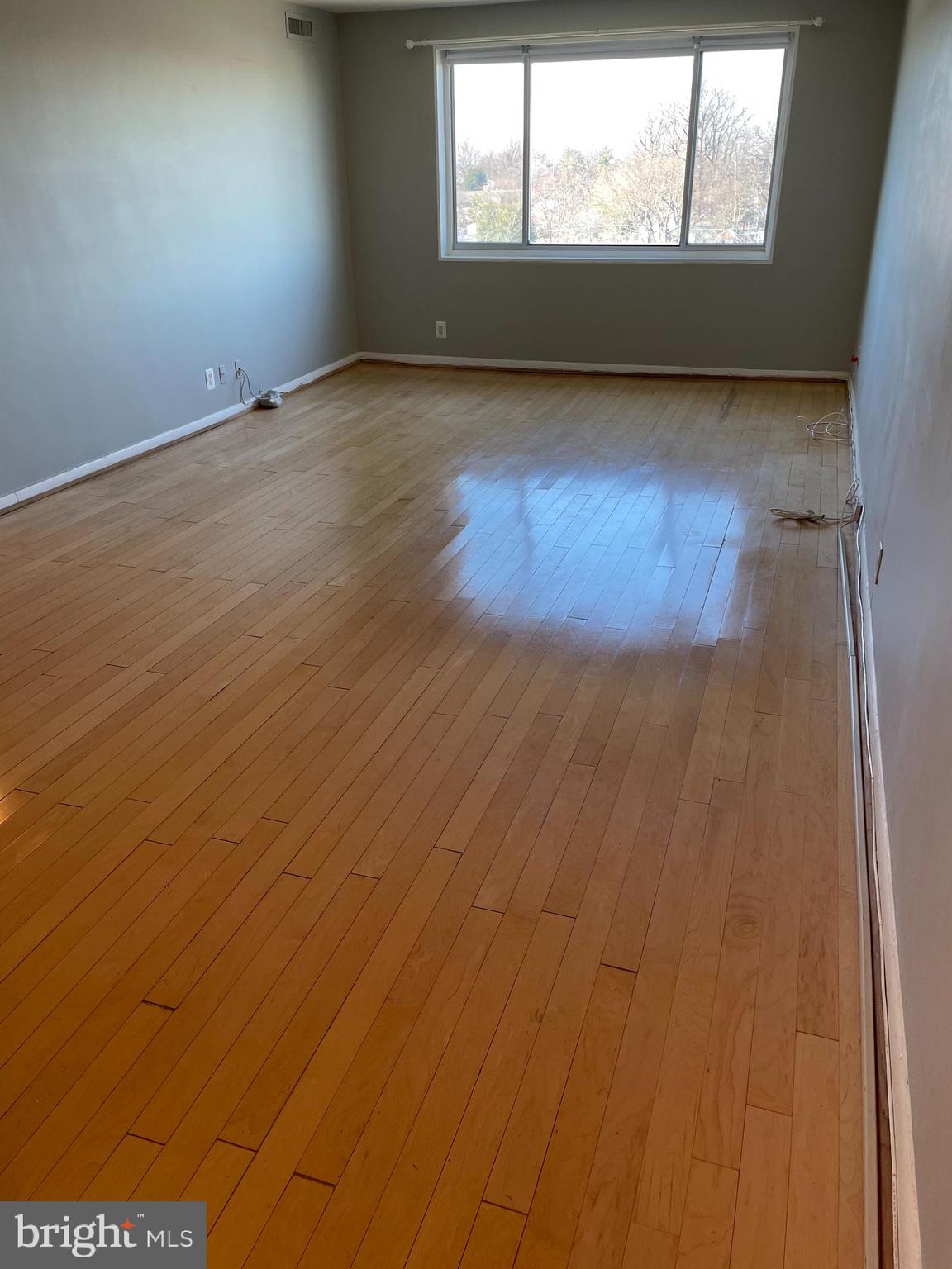 8315 North Brook Lane, Unit 21004 Bethesda, MD 20814 - Photo 4 of 12 an empty room with wooden floor and windows