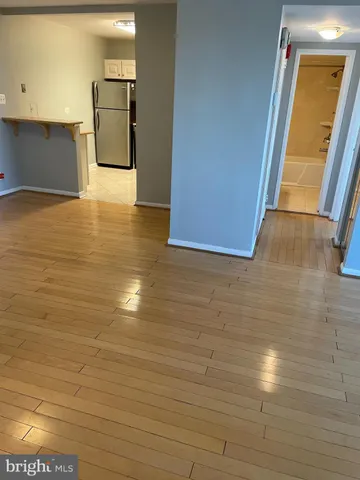 a view of empty room with wooden floor