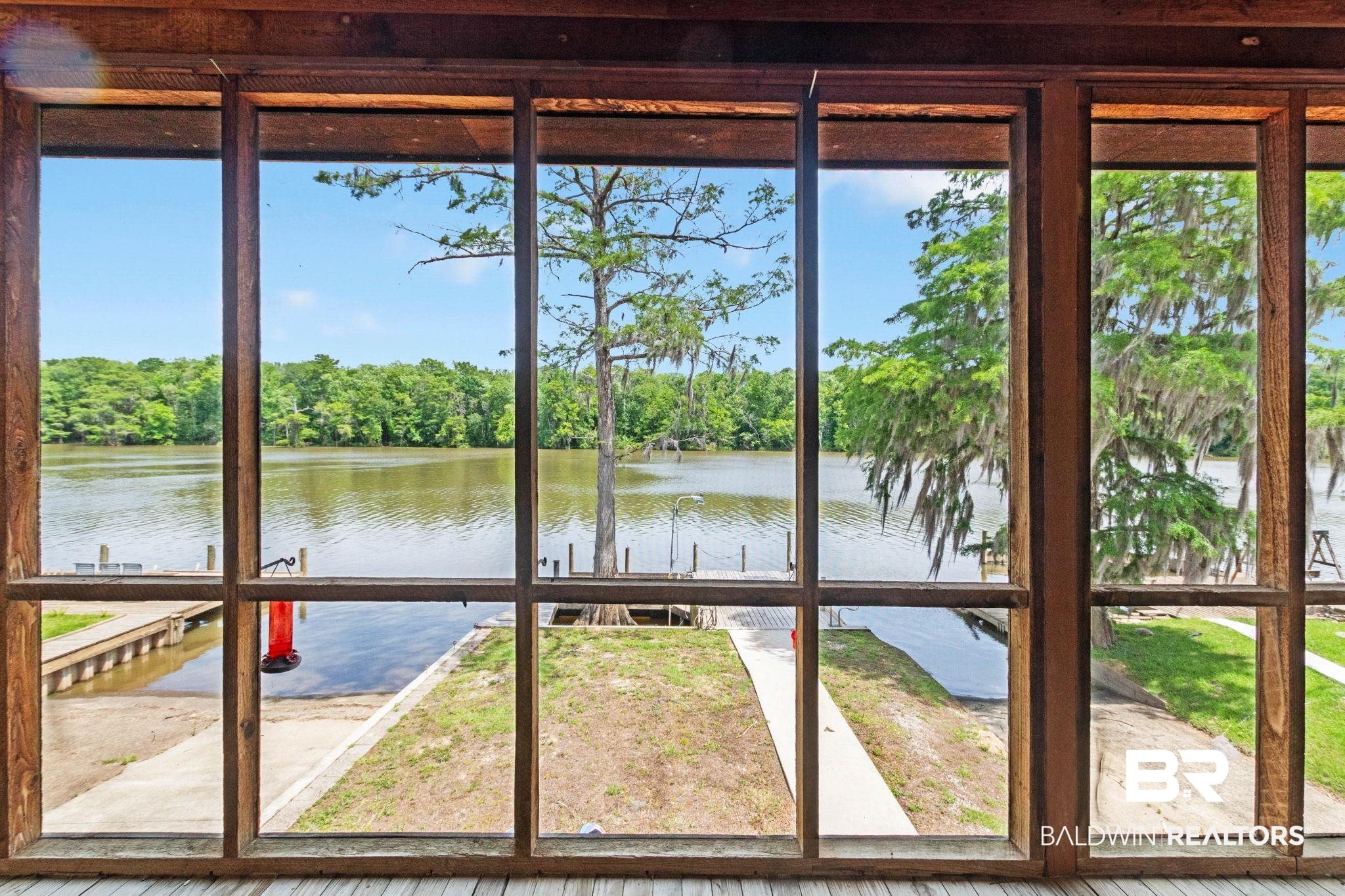 8153 Bryant's Lndg Road Stockton, AL 36579 - Photo 2 of 87 Expansive water frontage featuring a boat ramp, adjacent dock, and mature trees framing the river