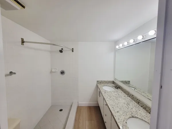 a bathroom with a granite countertop sink a toilet and shower