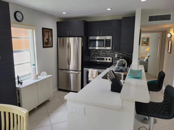 a kitchen with stainless steel appliances a refrigerator and a stove top oven