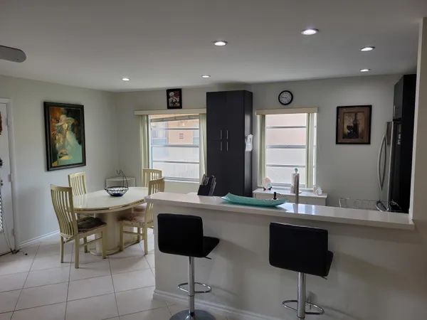 a kitchen with a dining table chairs and sink