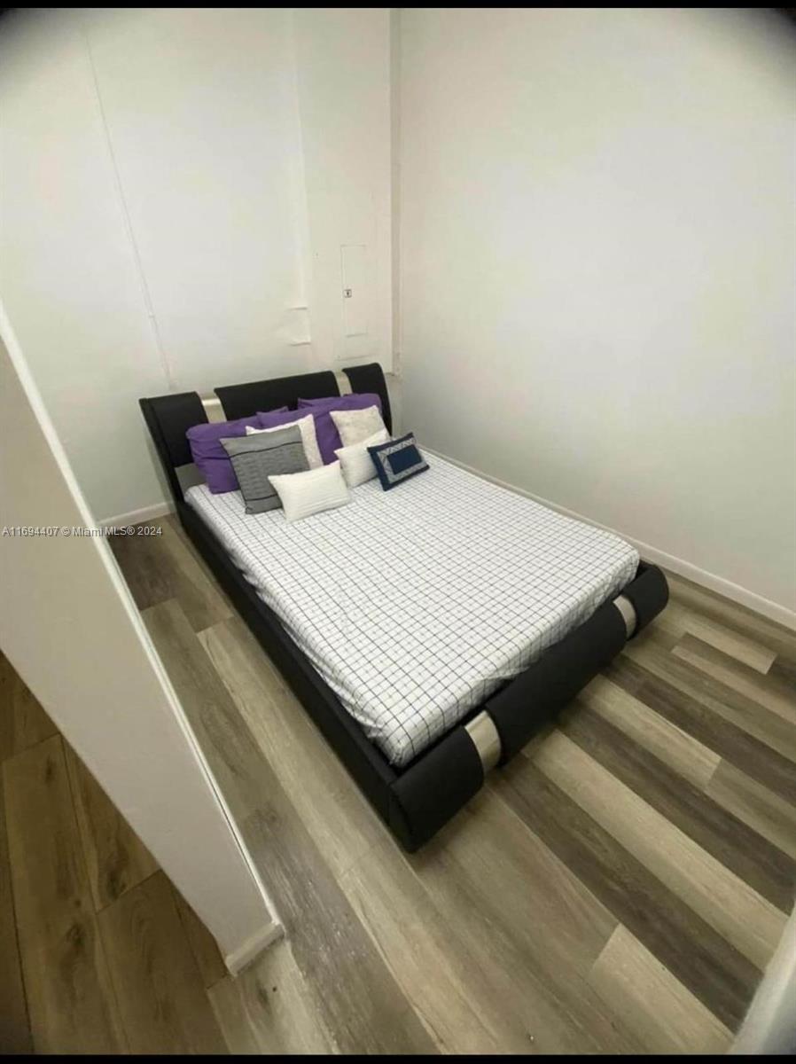 2012 Southeast 15th Street, Unit 1 Homestead, FL 33035 - Photo 2 of 12 a bed sitting in a bedroom next to a window