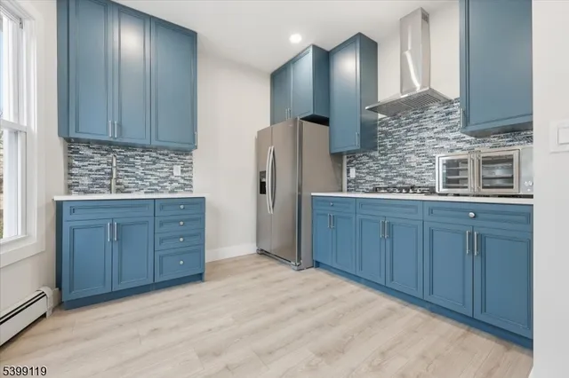 a kitchen with stainless steel appliances granite countertop wooden cabinets a refrigerator and a sink