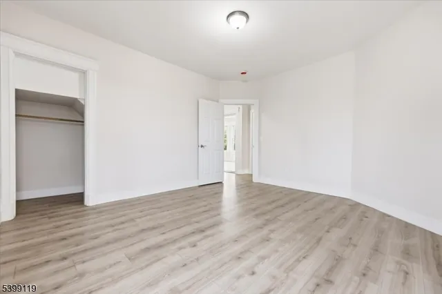 an empty room with wooden floor and closet