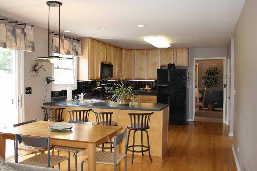 114 Barnes Road Elgin, IL 60124 - Photo 2 of 15 a kitchen with stainless steel appliances granite countertop a refrigerator a stove a kitchen island a dining table and chairs