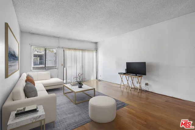 a living room with furniture a flat screen tv and a large window