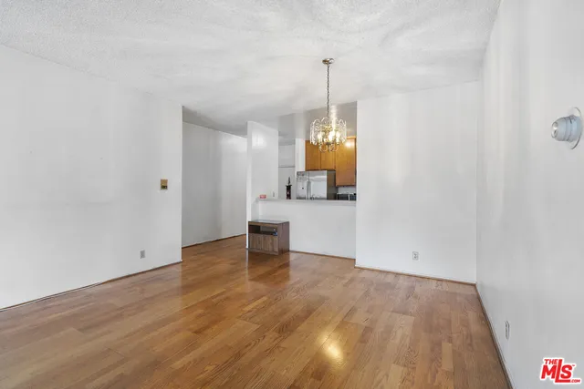 a view of empty room with wooden floor and sink