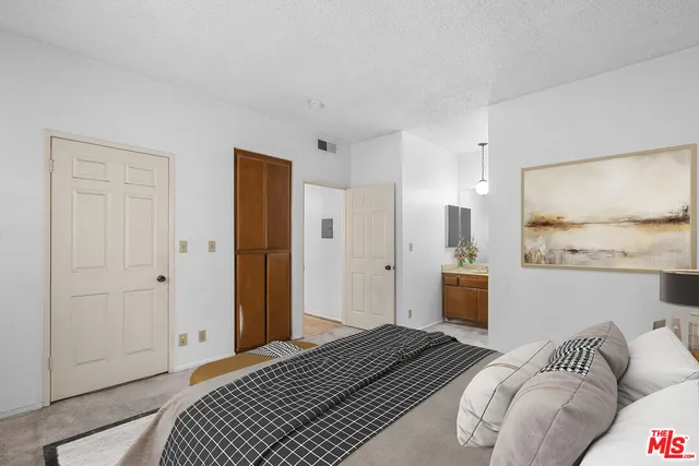 a bedroom with a bed and a painting on the wall