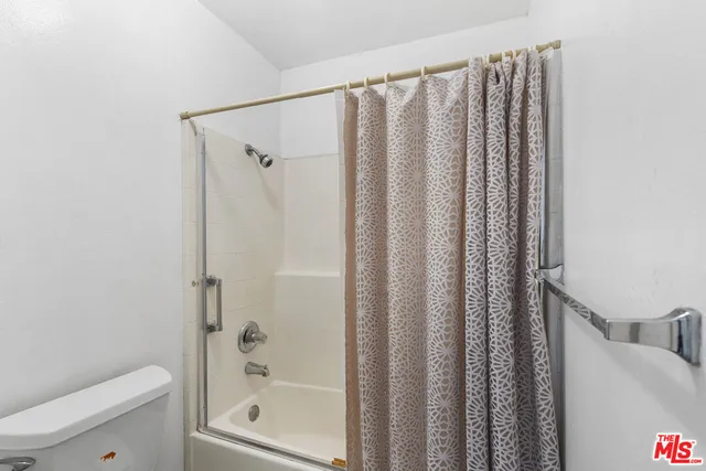 a bedroom with a large bed and a flat tv screen on the dresser