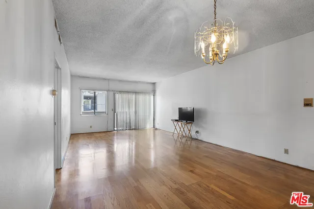 a view of empty room with wooden floor and window