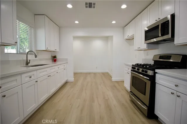 a kitchen with sink a microwave and cabinets