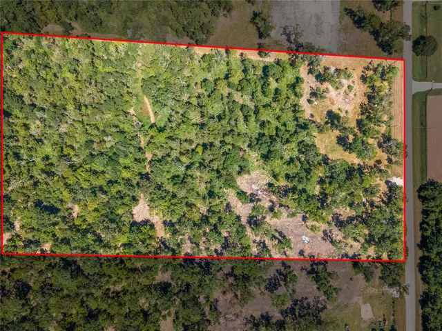 an aerial view of residential houses with outdoor space and trees