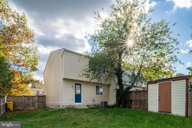 a view of a backyard with couches with wooden fence and plants