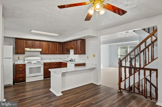 a kitchen with stainless steel appliances kitchen island wooden floors and white cabinets