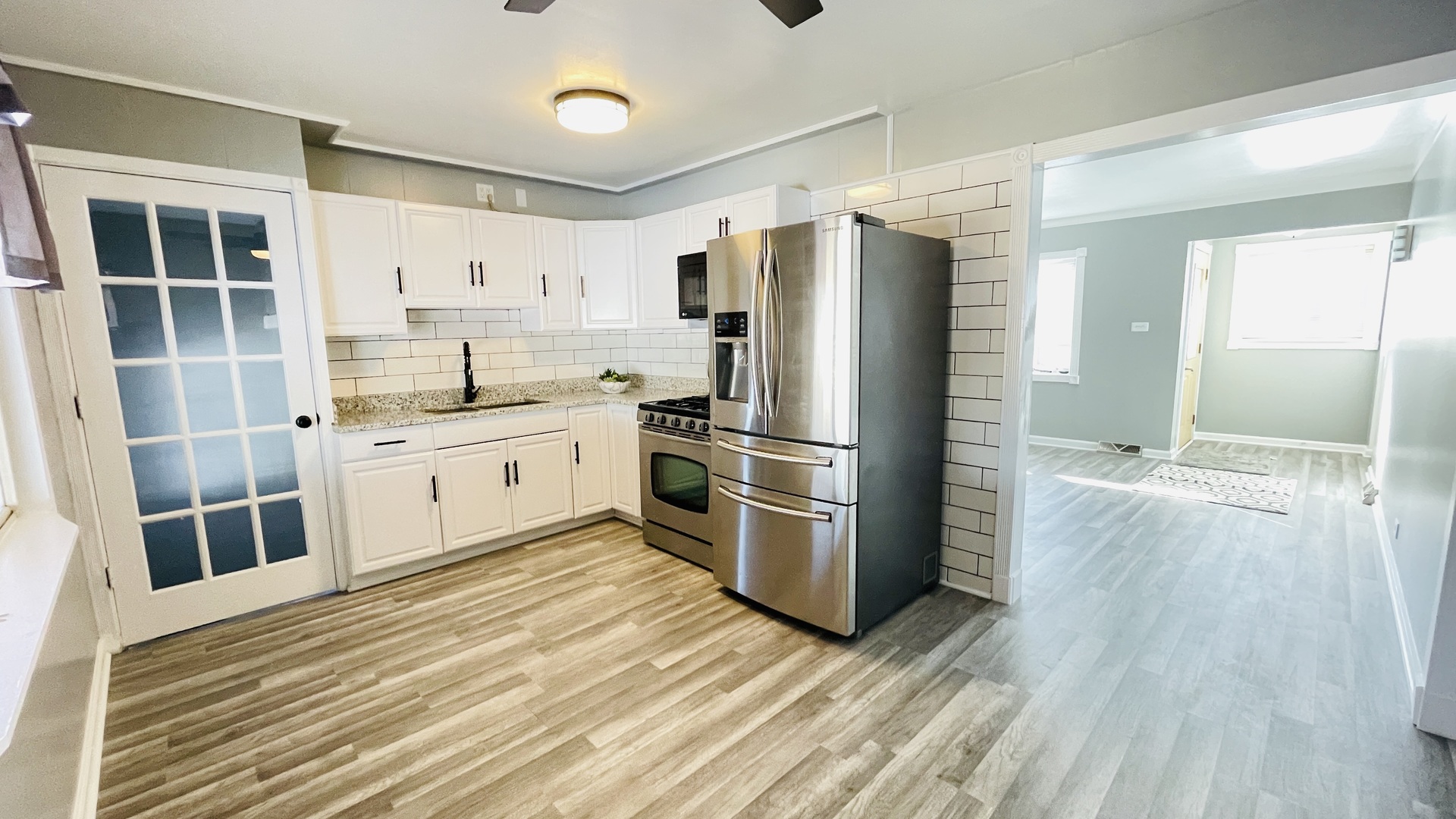 Undisclosed Address Addison, IL 60101 - Photo 5 of 26 a kitchen with a refrigerator a sink and dishwasher with wooden floor