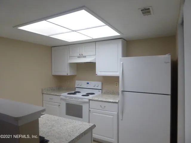 a kitchen with a stove a refrigerator and a sink