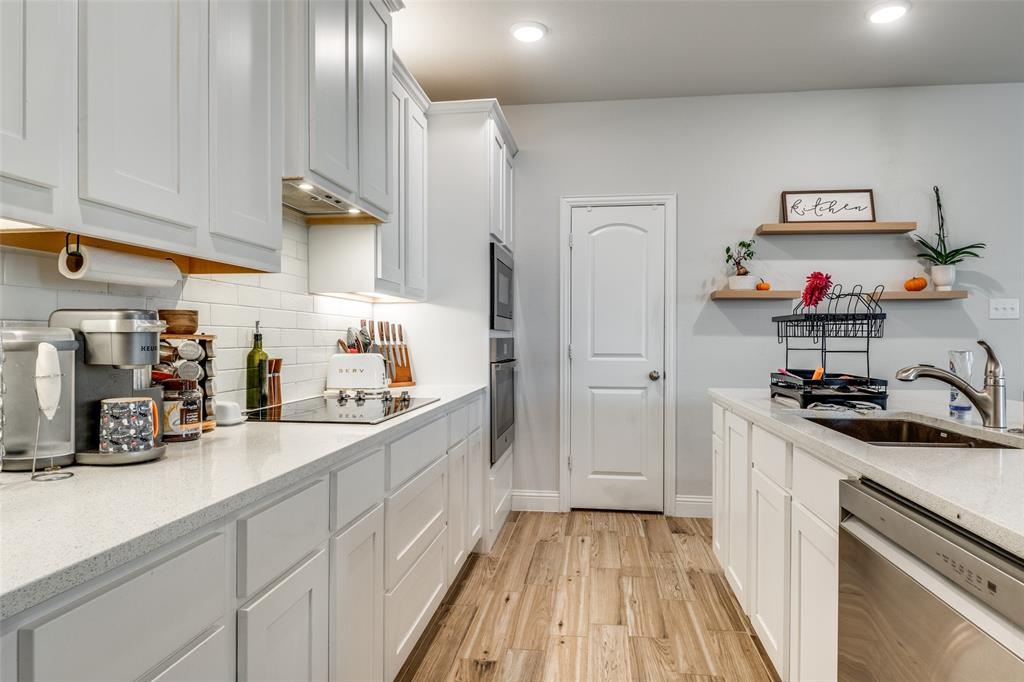 8413 Alba Lane Rowlett, TX 75089 - Photo 12 of 25 a kitchen with sink cabinets and stove top oven