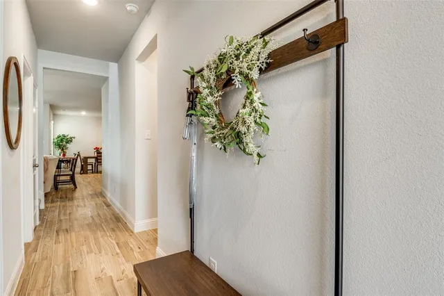 a view of a hallway with wooden floor and a potted plant