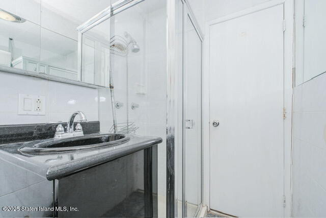 25 Berry Avenue West Staten Island, NY 10312 - Photo 12 of 24 a bathroom with a granite countertop sink and a mirror
