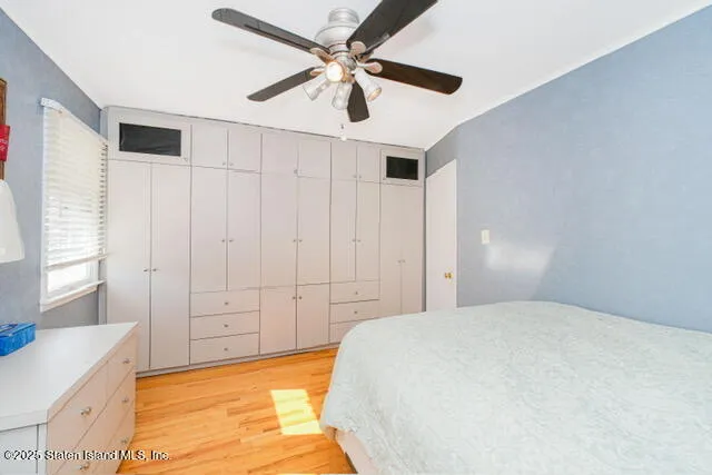 a spacious bedroom with a bed and a ceiling fan