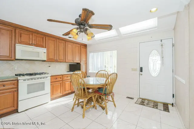 a kitchen with stainless steel appliances granite countertop a stove a sink dishwasher and a dining table with cabinets