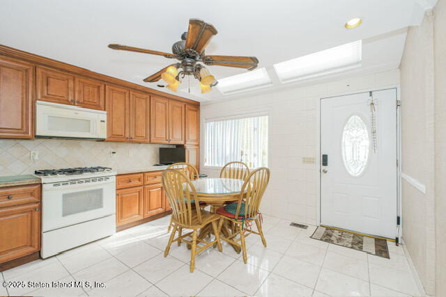 25 Berry Avenue West Staten Island, NY 10312 - Photo 5 of 24 a kitchen with stainless steel appliances granite countertop a stove a sink dishwasher and a dining table with cabinets