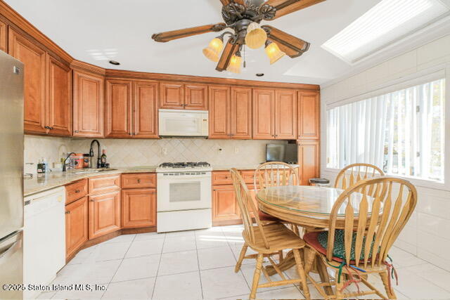 25 Berry Avenue West Staten Island, NY 10312 - Photo 8 of 24 a kitchen with stainless steel appliances granite countertop a sink a stove a dining table and chairs with wooden floor