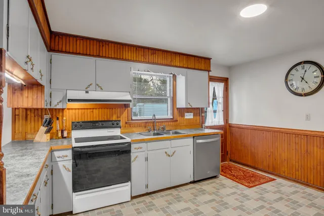 a kitchen with white cabinets and white appliances