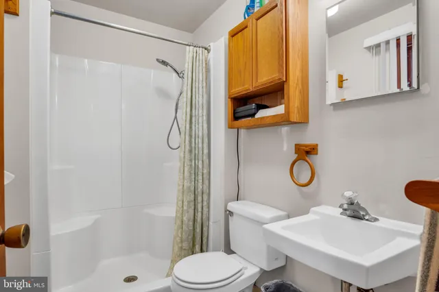 a view of a hallway with wooden floor and living room