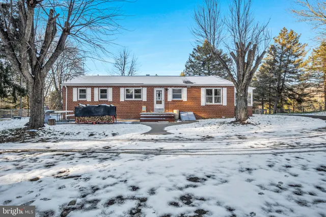 a view of a house with a yard covered in snow