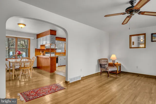 a living room with stainless steel appliances granite countertop a table and chairs in it