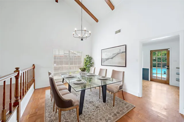 a view of an empty room with wooden floor and windows