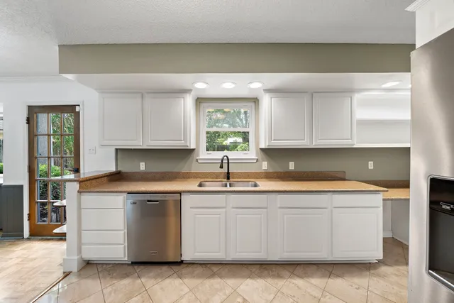 a kitchen with stainless steel appliances granite countertop a refrigerator a stove and a sink