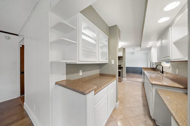 a kitchen with stainless steel appliances granite countertop a sink a stove and a refrigerator