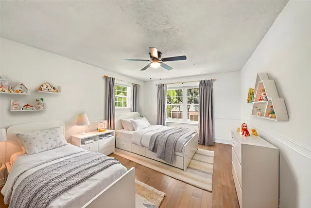 a bathroom with a granite countertop double vanity sink a mirror and a toilet