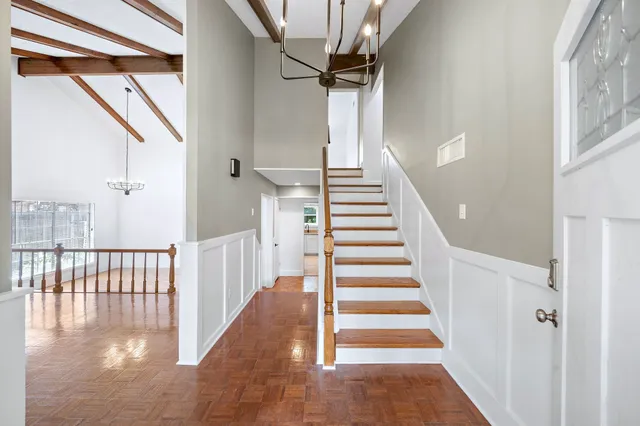a view of staircase with lots of frames on wall and wooden floor