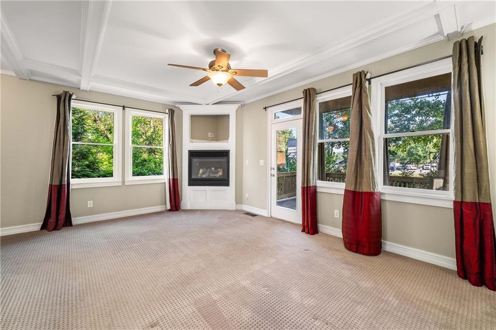 911 Monroe Circle Northeast Atlanta, GA 30308 - Photo 27 of 86 an empty room with windows fireplace and a chandelier fan